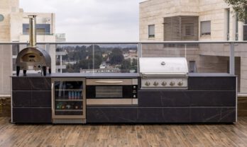 מטבח חוץ למרפסת עם גריל מובנה, כיור, משטח עבודה ואחסון במרפסת עירונית